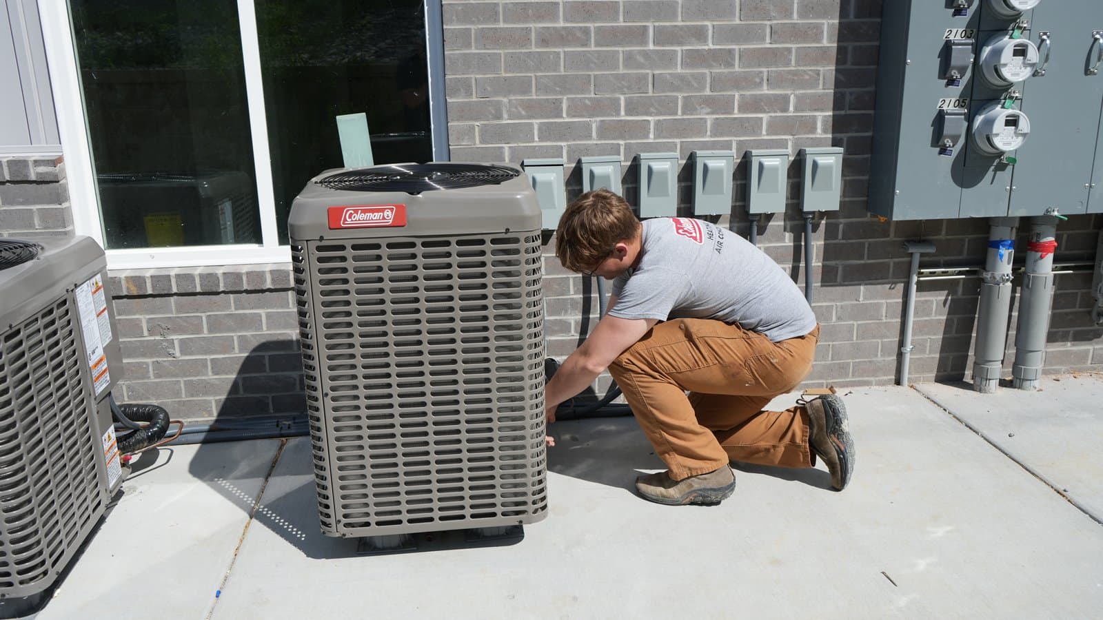 ATC technician servicing a Coleman condenser unit on a commercial job